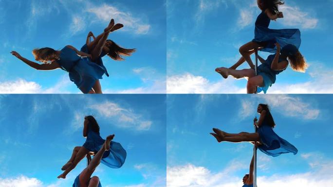 两个穿着蓝色裙子的钢管女舞者在天空中旋转