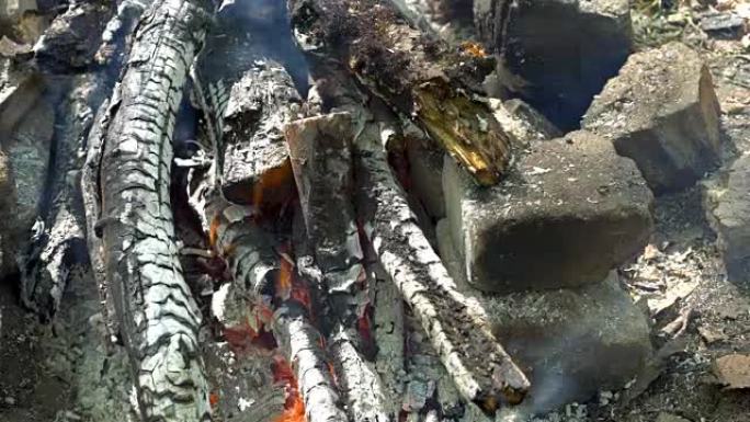 木制原木用橙色火焰在石头中燃烧，变成煤。准备烧烤。
