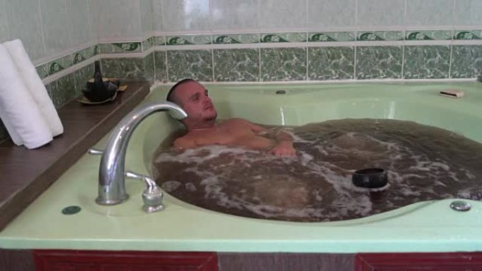 一名男子用矿泉水在草药浴中休息