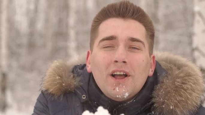 一个年轻人在雪地上吹的特写镜头。