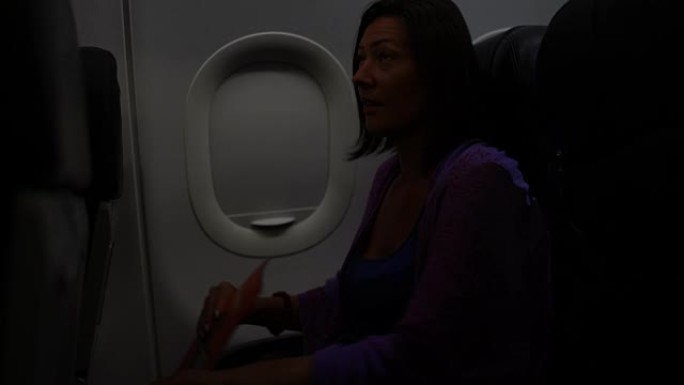 一个女人在飞机上看杂志