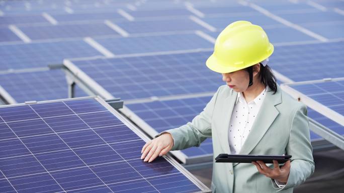 女性工程师拿着平板在光伏太阳能发电站工作