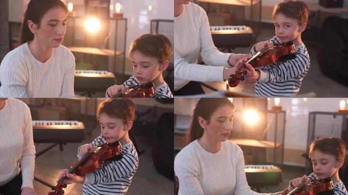 年轻女子教小男孩如何拉小提琴
