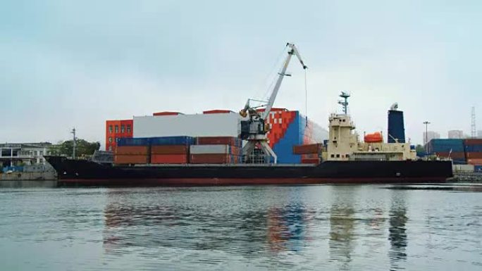 港口起重机从海上货船的甲板上卸下装有货物的集装箱