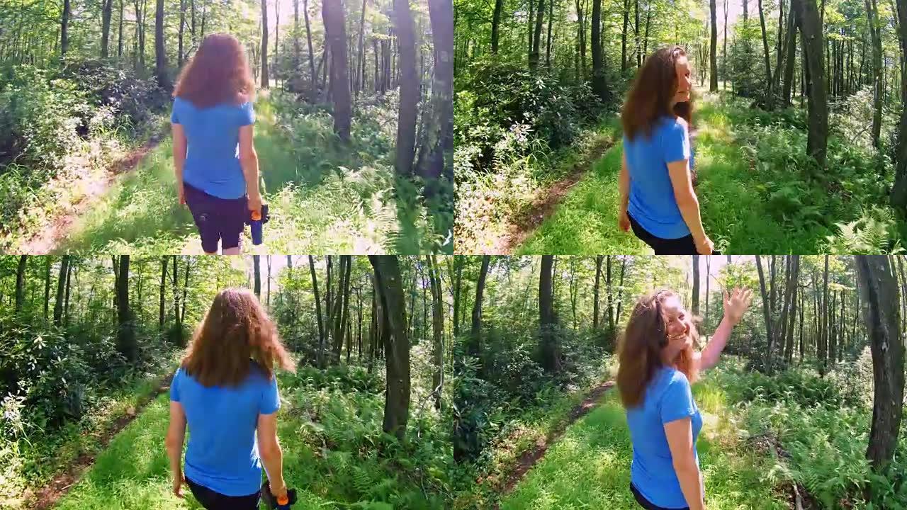 这位16岁的白人白人，长发，女孩在森林小径上徒步旅行，回头看着挥手。