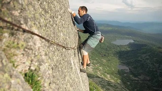 一个勇敢的年轻人独自爬上高高的岩石，没有保险。