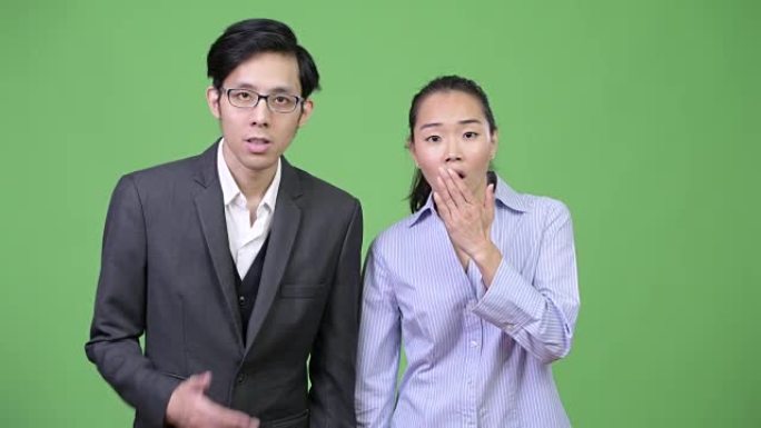 年轻的亚洲商业夫妇在一起看起来很震惊