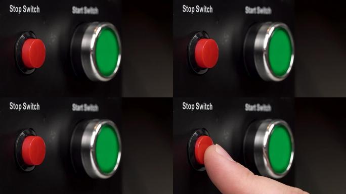框架中两个按钮的特写。绿色启动开关和红色停止开关按钮。手指按下红色停止开关按钮。