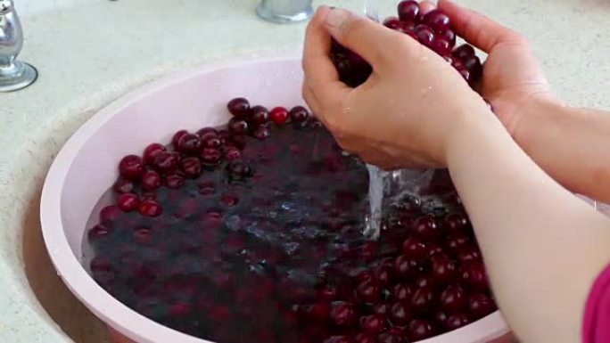 一个女人正在洗樱桃做樱桃果酱，