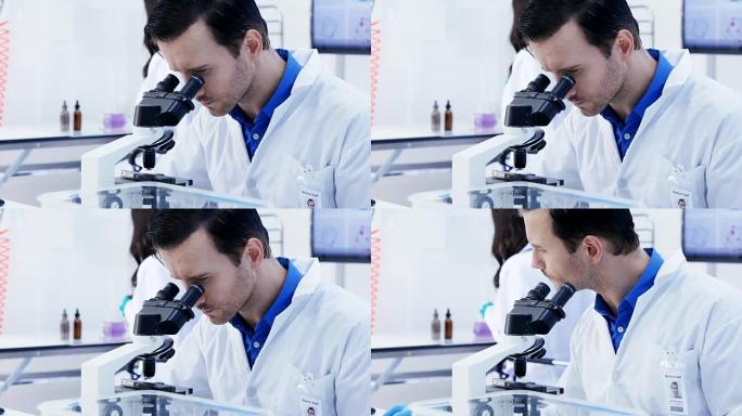 在实验室里看显微镜的男科学家。有科学概念的人。4k分辨率。