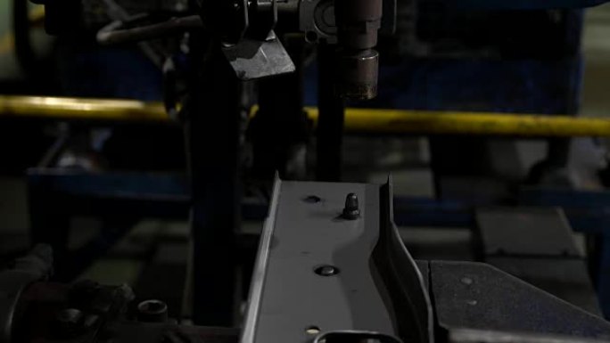 汽车点焊机正在将螺母焊接到汽车零件上