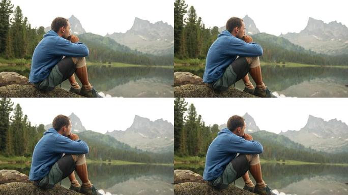 一个年轻人坐在山湖的岸边，吹口琴。