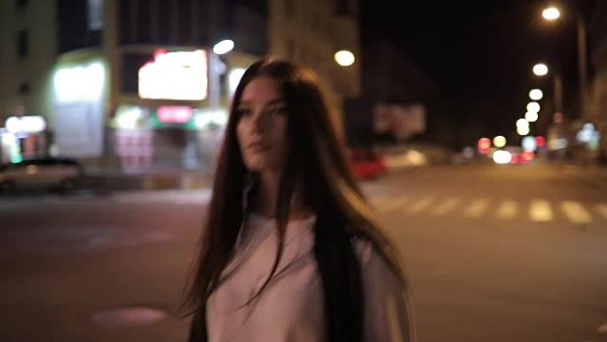 孤独的女人在午夜城市市中心散步