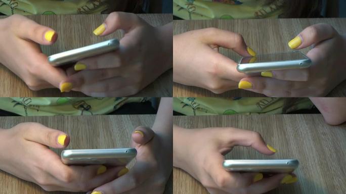 一个用智能手机修指甲的女孩的手