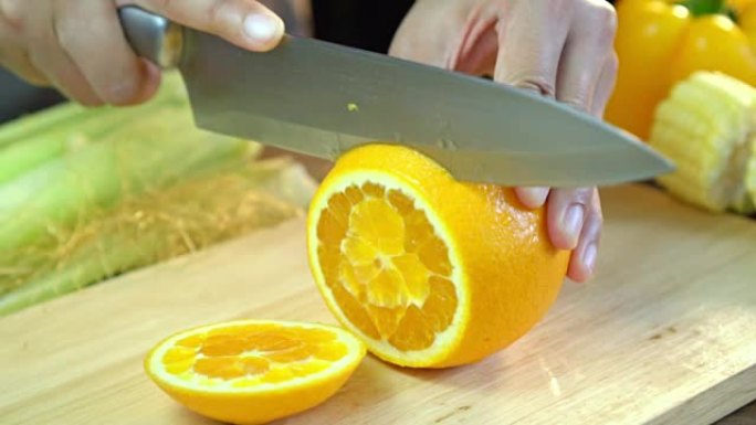 亚洲妇女在家里厨房的木板上切割干净的鲜橙色水果的特写镜头，滑动镜头