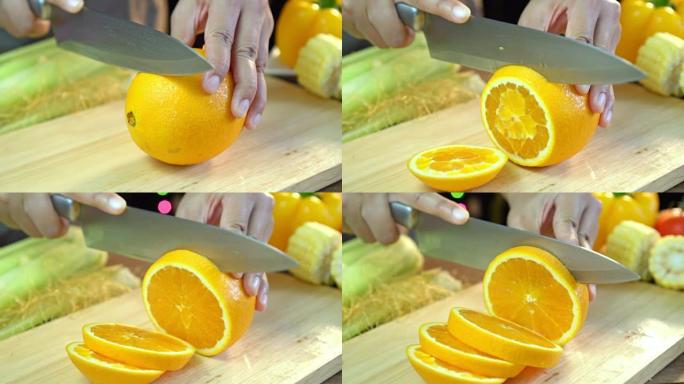 亚洲妇女在家里厨房的木板上切割干净的鲜橙色水果的特写镜头，滑动镜头