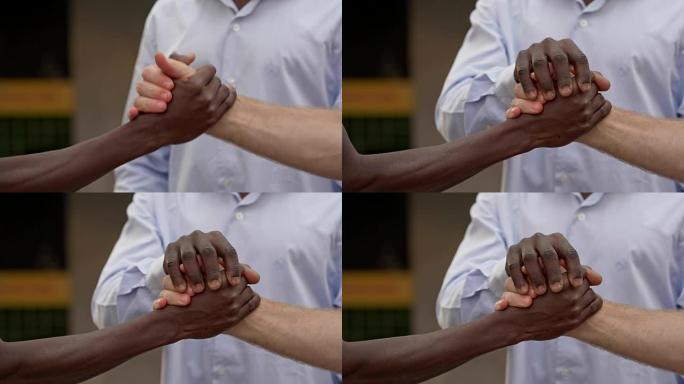 所有颜色的友谊。黑人和白人手抖