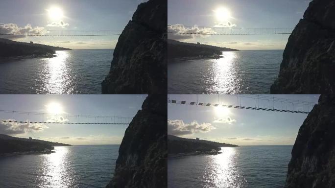 海上岩石与危险波浪和石头之间的绳索桥的鸟瞰图