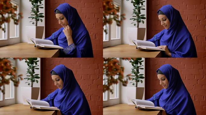 年轻漂亮的女人穿着蓝色头巾看书，坐在咖啡馆里，鼻子穿孔的迷人女士