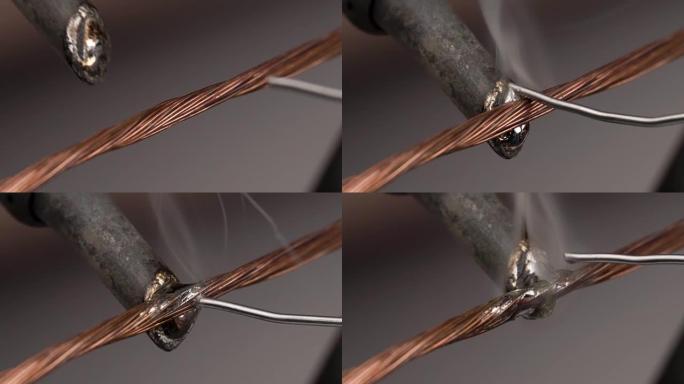 使用手动烙铁工具用电焊料焊接绞合铜线。特写宏。