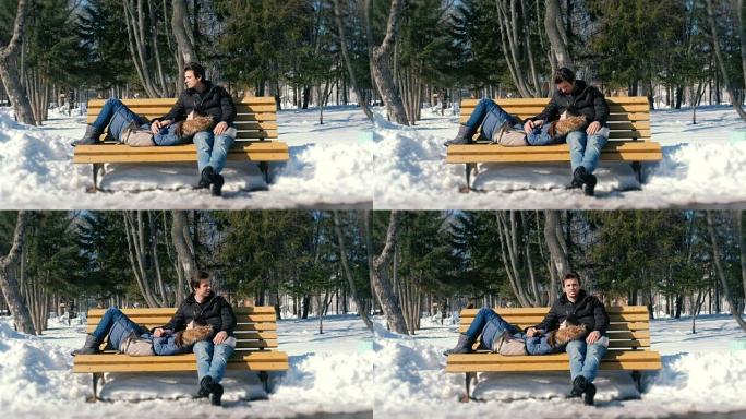 男人和女人一起在冬季城市公园的长凳上休息。阳光明媚的冬日。