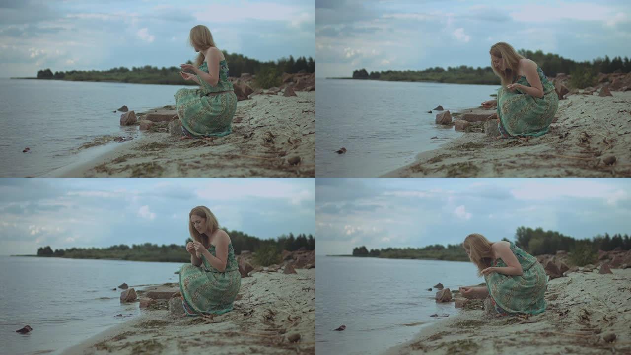 无忧无虑的女人在海滩上收集海石