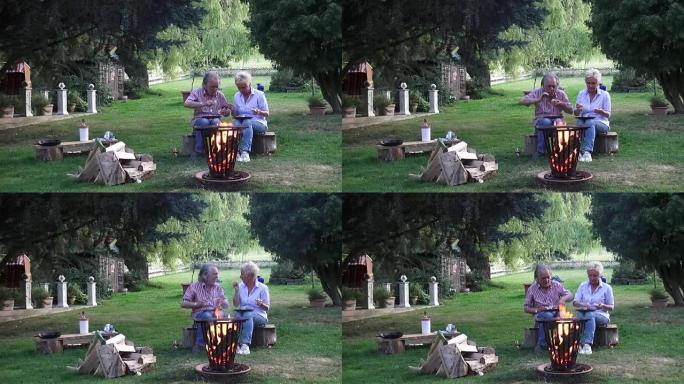 这对幸福的夫妇期待着在篝火周围的火篮中燃烧的同时吃煎鸡蛋。