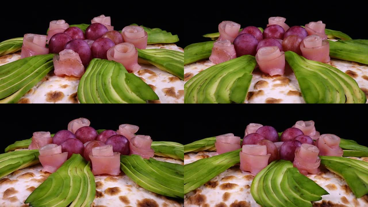 鳄梨，葡萄和装饰火腿的比萨饼，如玫瑰旋转