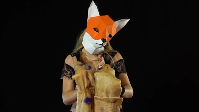 金发女孩用狐狸面具纸用猪皮覆盖。黑色背景。4k UHD