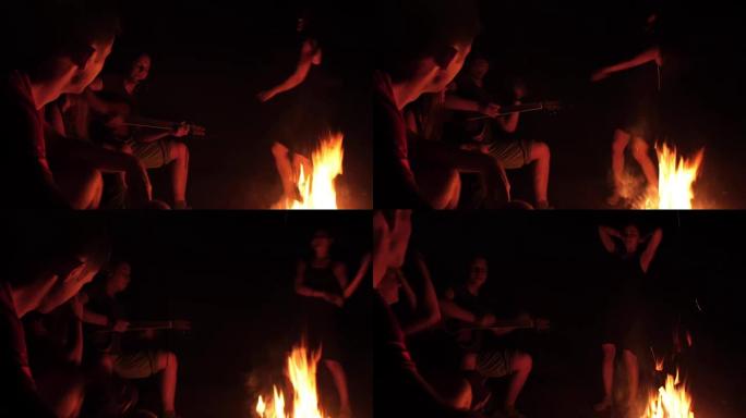 年轻朋友晚上在篝火旁嬉戏跳舞