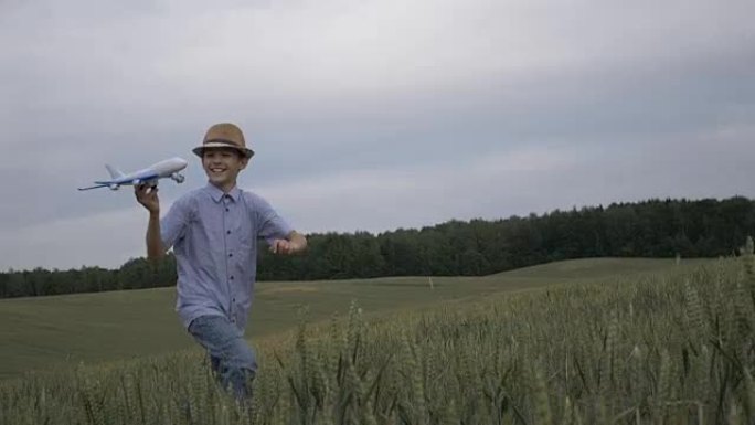 商界男孩梦想家手里拿着一架飞机横穿田野