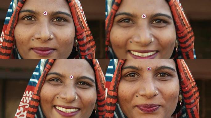 一个华丽的印度女人的脸的极端特写笑笑快乐看着穿着传统服装的相机头部覆盖宾迪漂亮的珠宝在家自由爱静态镜