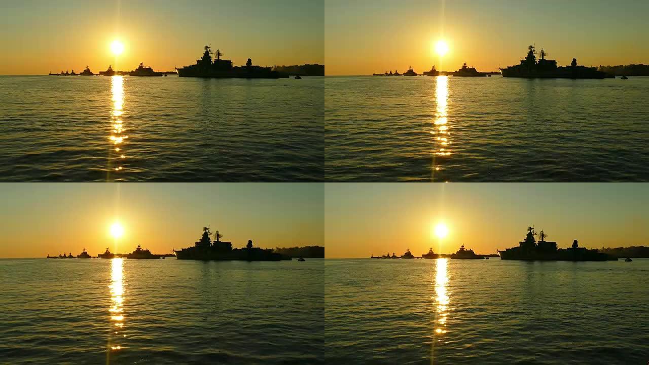 日落时海湾中的军舰剪影