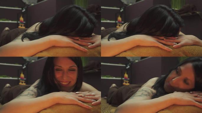 漂亮的黑发女人躺在按摩床上