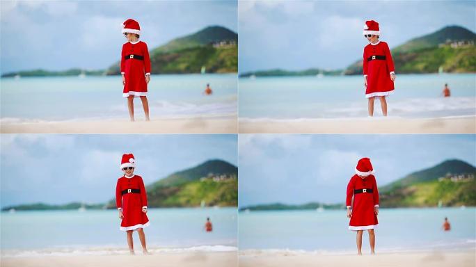 圣诞节假期在白色海滩上戴着圣诞帽的小女孩