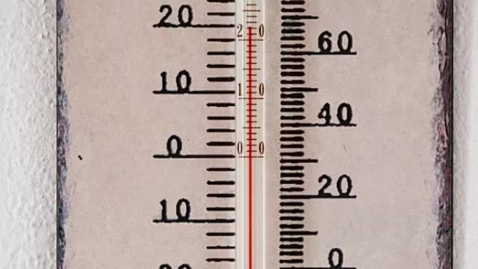 在温度计上缩放。墙上有摄氏和华氏刻度的温度计。夏季的温度计显示温度为22摄氏度。