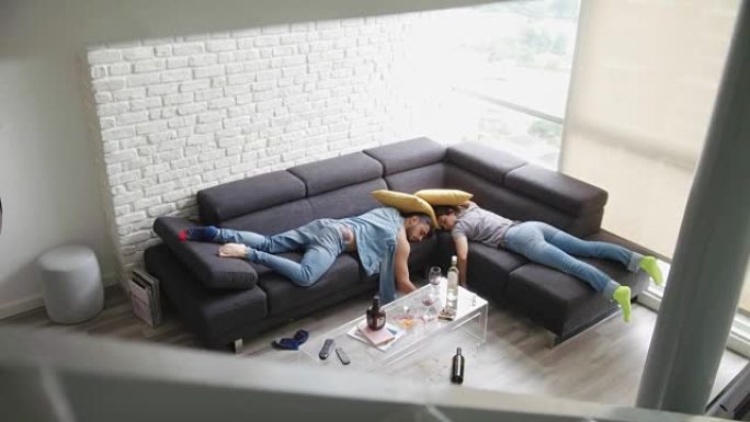 派对结束后，醉酒的朋友睡在凌乱的房间里的沙发上