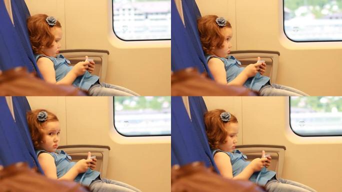 女童在火车上玩智能手机。