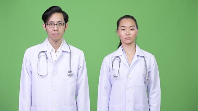 年轻的亚洲夫妇医生一起停止手势