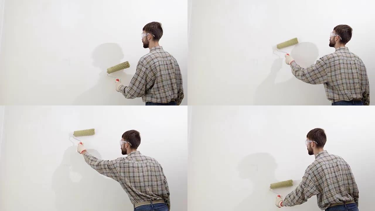 画家在工作，用滚筒粉刷墙壁，画家房子的概念