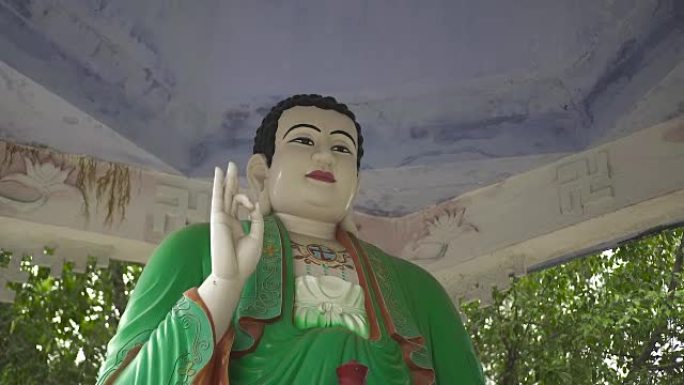 佛塔里穿着绿色衣服的佛像特写。古代寺庙中的雕塑坐佛。亚洲宗教和文化