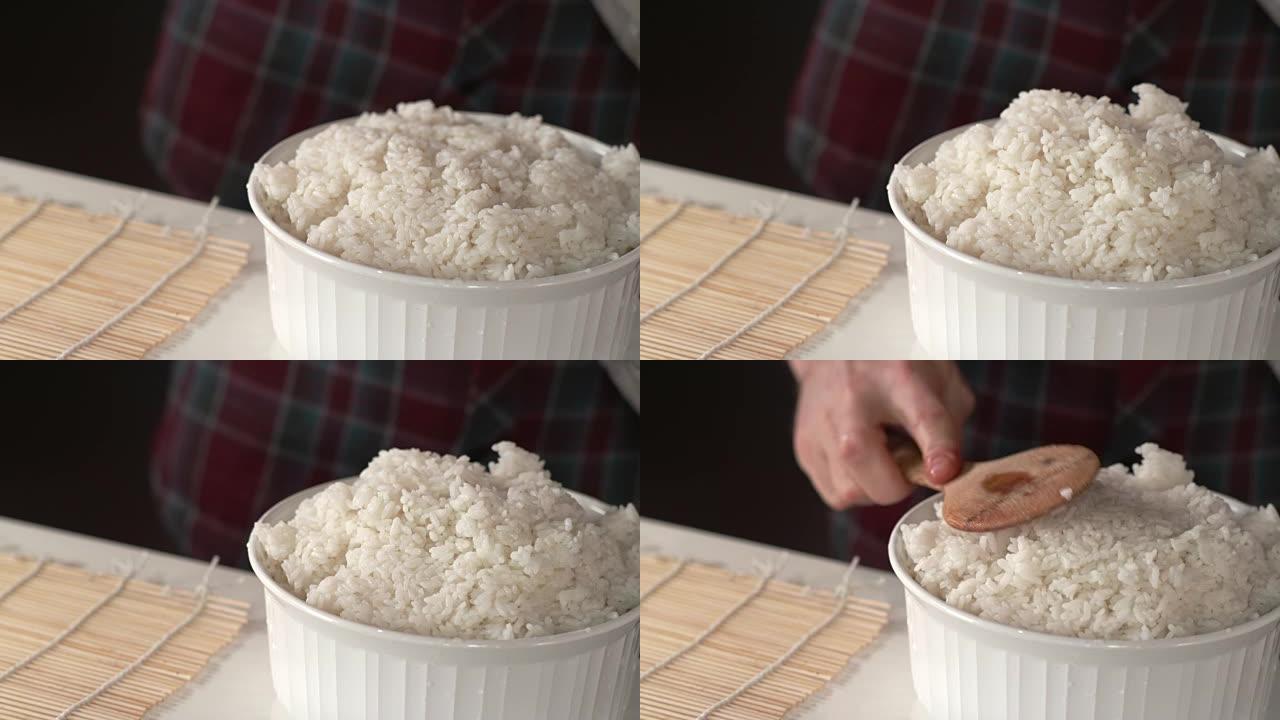 寿司厨师用竹制木勺用白米饭装满大碗
