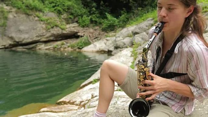 年轻的成年女性在大自然的水中演奏萨克斯管