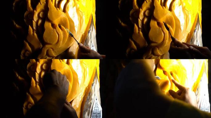 熟练男子雕刻蜡烛的特写镜头是泰国佛教大斋节的美丽图案