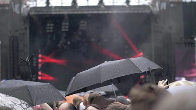 人们在雨中参加户外音乐会