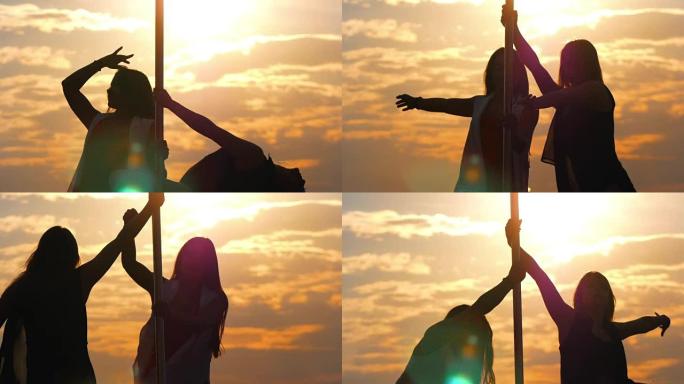 两名灵活女性的剪影在日落时表演钢管舞