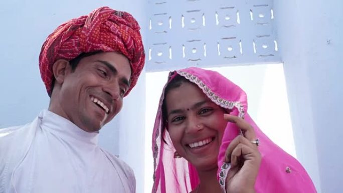 一个新结婚的印度夫妇在民族服装摆姿势的照片和视频在拉贾斯坦邦，印度的特写