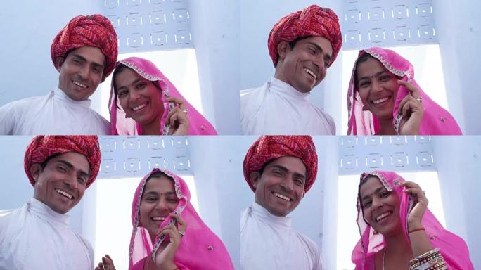 一个新结婚的印度夫妇在民族服装摆姿势的照片和视频在拉贾斯坦邦，印度的特写