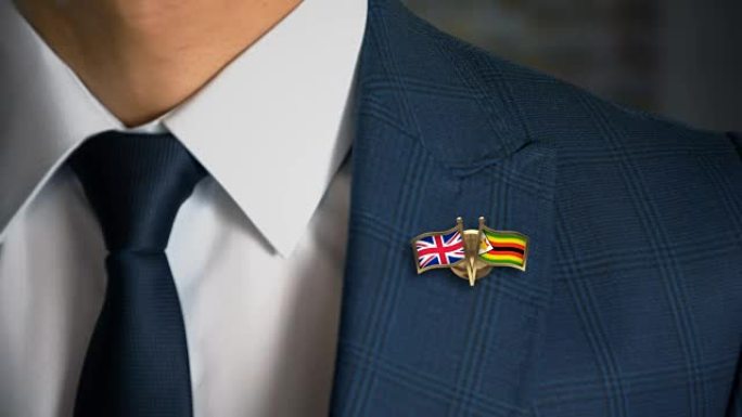 商人带着朋友国家的旗帜走向相机英国-津巴布韦