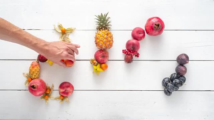 用五颜六色的水果写的 “生物” 一词。由物体制成的排版。用水果创造排版。